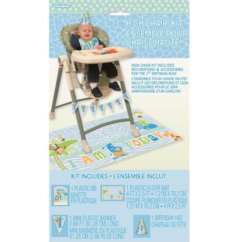 Baby in a high chair wearing a birthday hat, with a blue party kit including a banner and coordinating floor mat for a first birthday event