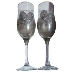 Two champagne flutes with glittery silver heart decals, standing side by side for a celebration.