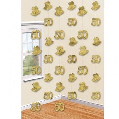 Gold 50 balloons and bow decorations hanging on a beige wall for a 50th birthday celebration, around a window with wood floor.