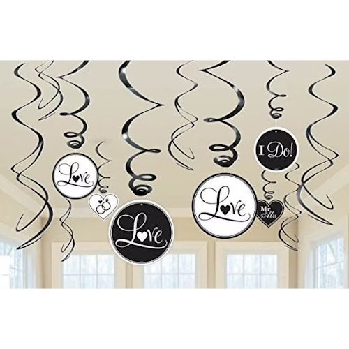Black and white circular signs with cursive 'Love' text, hanging from curling ribbons as ceiling decorations