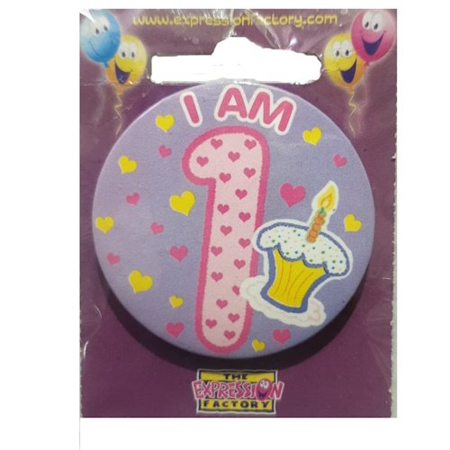 Round purple badge reading 'I AM 1' with pink number 1 and a cupcake, from party supply packaging.