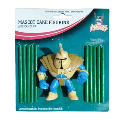 Packaged mascot cake figurine with a gold-armored blue figure flanked by two sets of green candles on teal packaging.