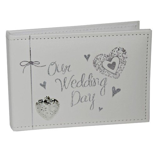 White wedding photo album with silver glitter text 'Our Wedding Day' and decorative hearts on a stitched cover with a small heart charm.