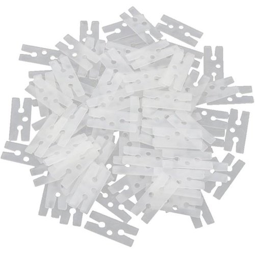Pile of small white plastic cable tie segments scattered together, ready for use or disposal