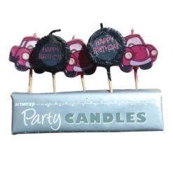 Birthday candles on sticks with round black toppers reading 'Happy Birthday,' placed on a blue 'Party Candles' box with pink car graphics in the background.