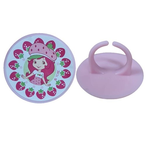 Purple circular toy disk showing a cartoon girl surrounded by strawberries, placed beside a matching purple silicone base with two curved arches.